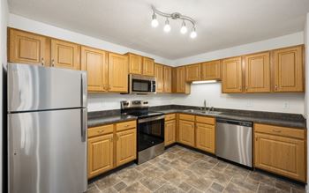 a kitchen with wooden cabinets and stainless steel appliances